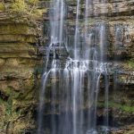 During a dryer October. The water flows from a cave and drops into a cave.