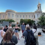 Still in Agia Eirini Square, the guide stopped to cover some history and invited us to peer over the corrugated metal walls (far left in the photo). (3968)