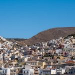 From the harbor, the Roman Catholic Cathedral of Saint George is at the top of the hill to the left and the Greek Orthodox Church is on the hill to the right. There is a significant Catholic population on Syros, about ⅓ of the permanent residents. After the Fourth Crusade, Syros was controlled by Venetian noble families beginning in the early 13th century. Although unusual in the islands, Syros developed a lasting Catholic community and the two communities have coexisted peacefully for generations. Interfaith marriages are now common, major festivals are often celebrated together, and Syros is widely regarded as one of Greece's best examples of religious harmony. (2931)