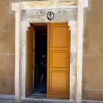 Instead of an imposing ceremonial entrance, the door feels almost understated—plain, heavy, and functional, without the rich ornamentation found elsewhere on Syros. It does not attempt to impress visitors with grandeur; it seems to invite quiet reflection instead. (3882)